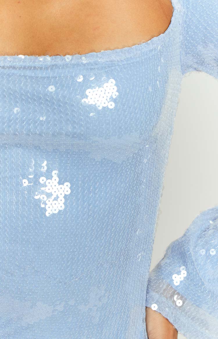 Close-up of the light blue sequin fabric with scattered white sequins, showing the square neckline and long sleeve
