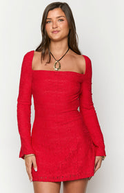 Close-up of the red floral lace fabric and square neckline of a long sleeve mini dress