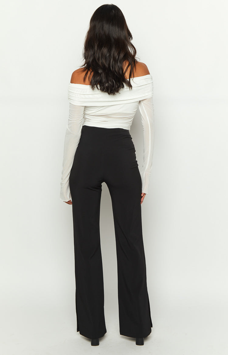 Rear view of black high-waisted pants with a smooth fit and subtle ankle slits