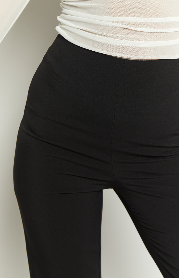 Close-up of the fitted hip and thigh of black pants with a subtle front seam