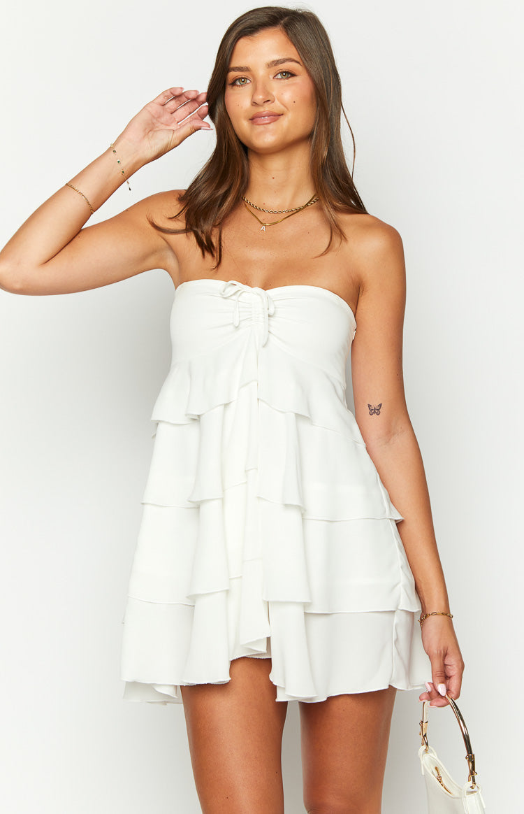 White strapless mini dress with a tiered ruffle skirt and a ruched drawstring detail on the bust