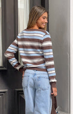 Rear view of a brown, blue, and white striped cardigan with a ribbed hem and cuffs