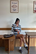 Full front view of a fitted brown, blue, and white stripe button-down cardigan with a V-neck and long sleeves