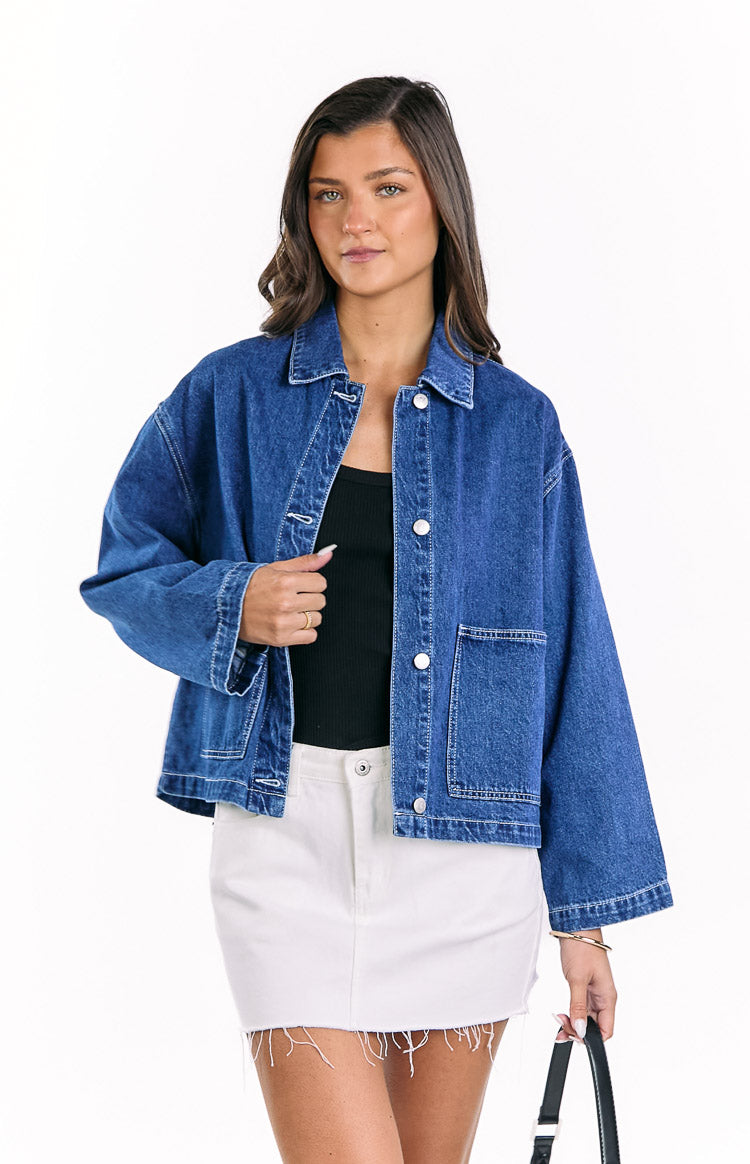 Mid wash blue denim jacket with contrast white stitching, silver buttons, and large front patch pockets, worn open