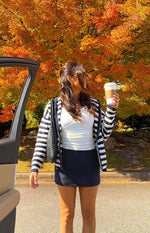 Open navy and white striped knit zip sweater showing ribbed cuffs and hem