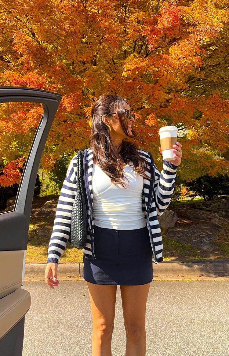 Open navy and white striped knit zip sweater showing ribbed cuffs and hem