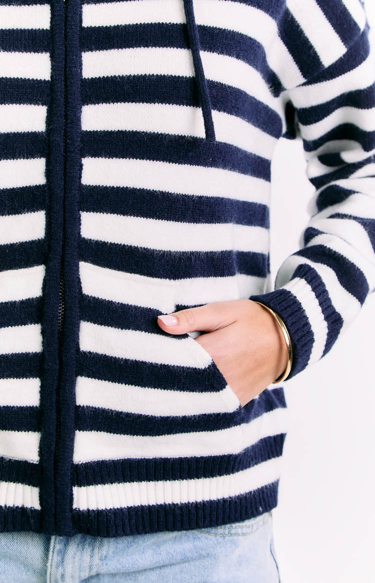 Close-up of the front zipper and side pocket on a navy and white stripe knit sweater
