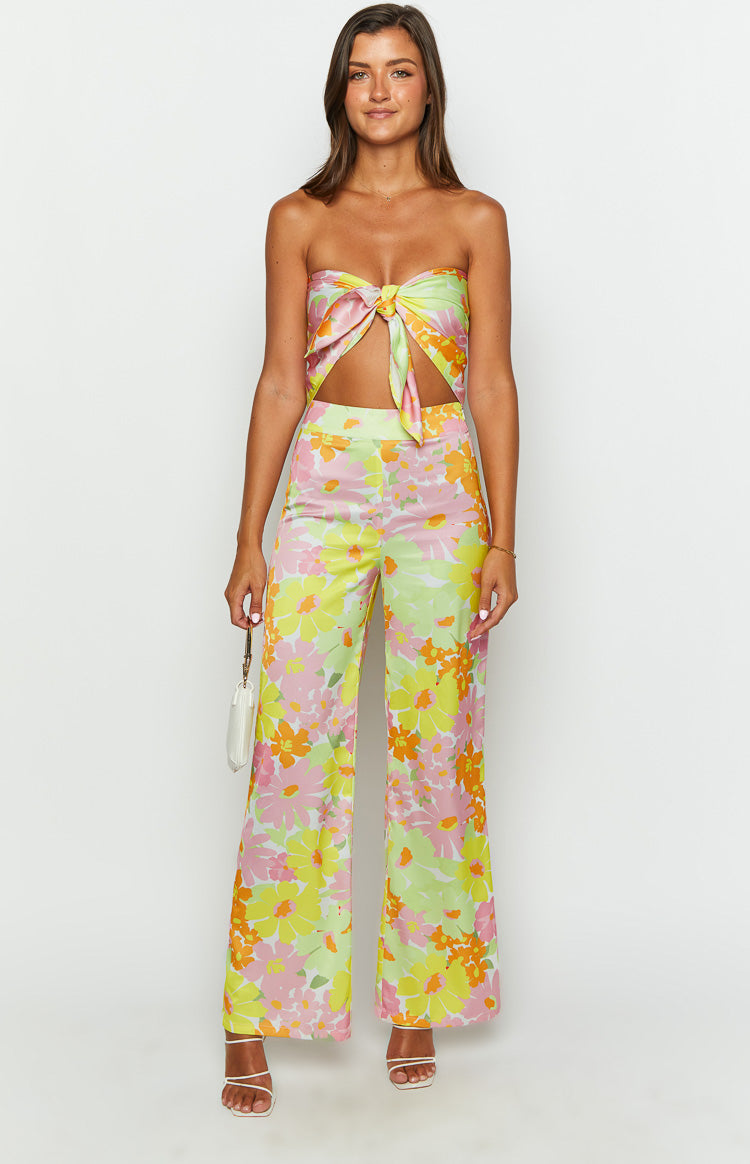 Full length yellow floral wide-leg pants with a high waist and large pink, orange, and lime green flowers
