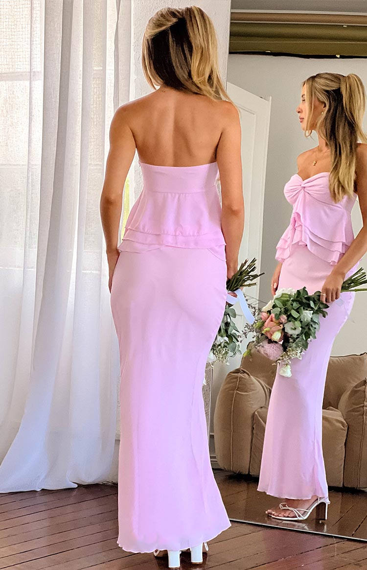 Rear view of a light pink maxi skirt, showing its fitted silhouette and flowing hem