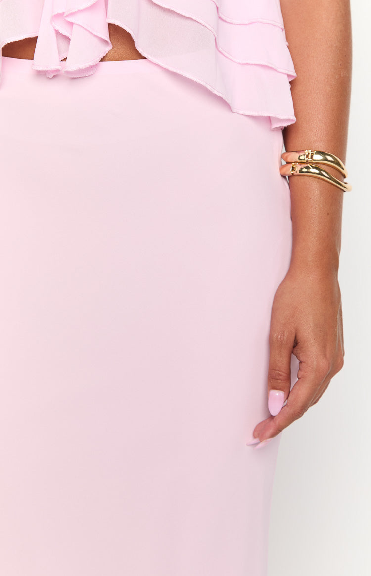 Close-up side view of the smooth light pink fabric of a fitted maxi skirt