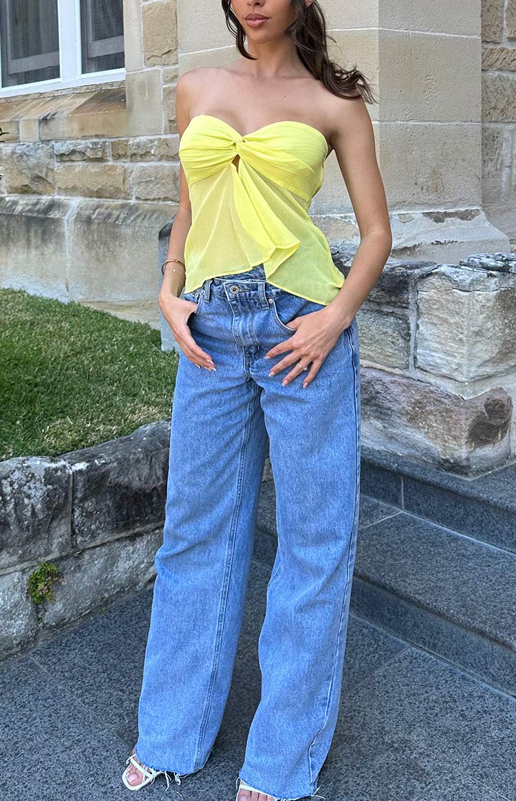 Full length light blue wide-leg jeans with a distressed hem and an uneven high waist