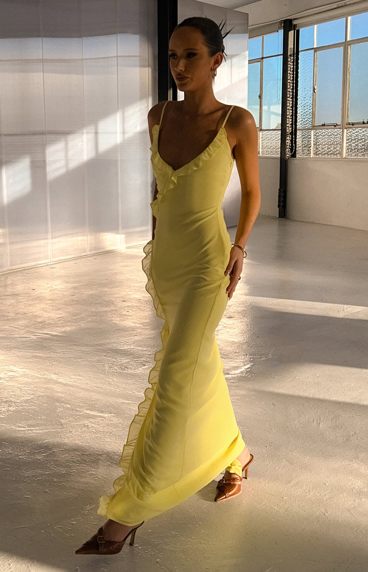 Side view of a yellow maxi dress with ruffles along the V-neckline and down the side seam