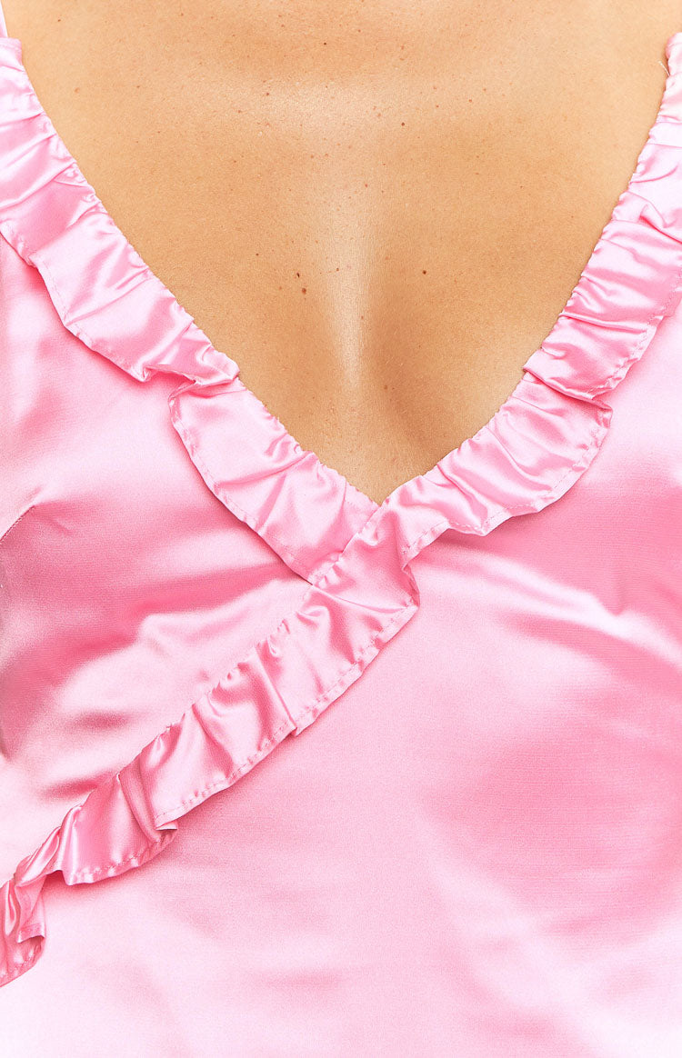Close-up of the pink satin V-neckline with delicate ruffle trim on the maxi dress