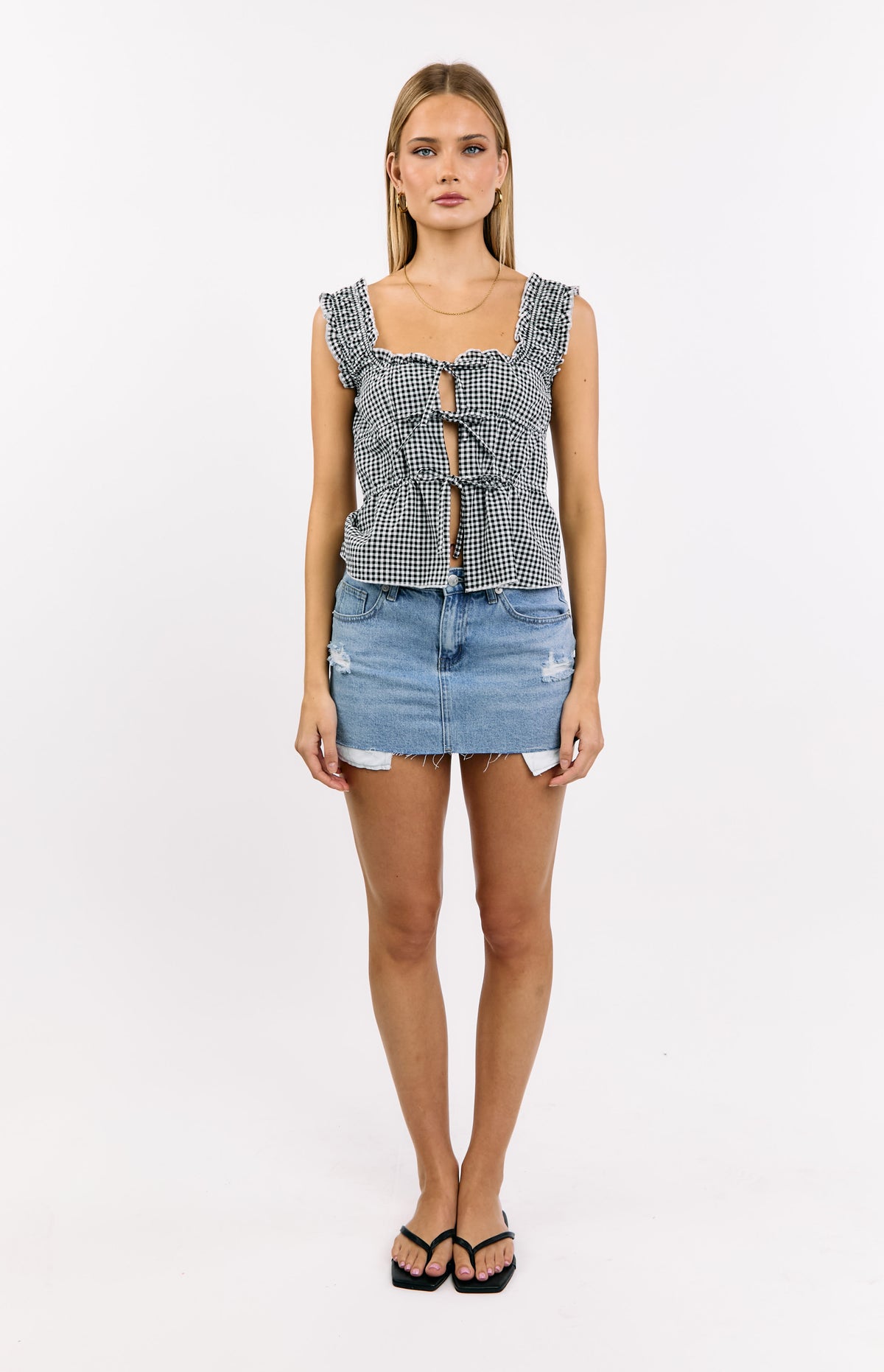 Front view of a black gingham tie top with a square neckline, ruffled shoulder straps, and multiple ties down the front
