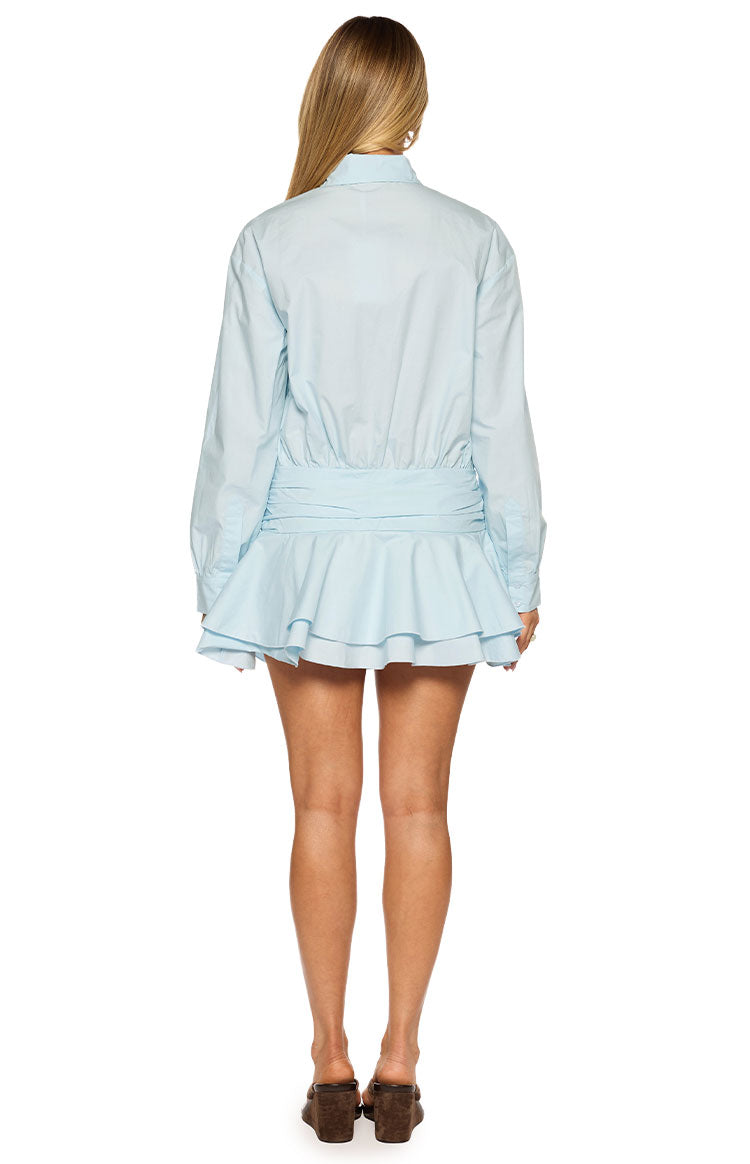 Rear view of a light blue long sleeve mini shirt dress with a ruched waist and tiered ruffled skirt