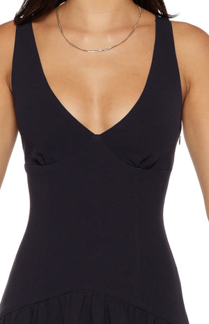 Close-up of the deep V-neckline, fitted bodice with subtle gathering, and side zipper of a navy crepe maxi dress