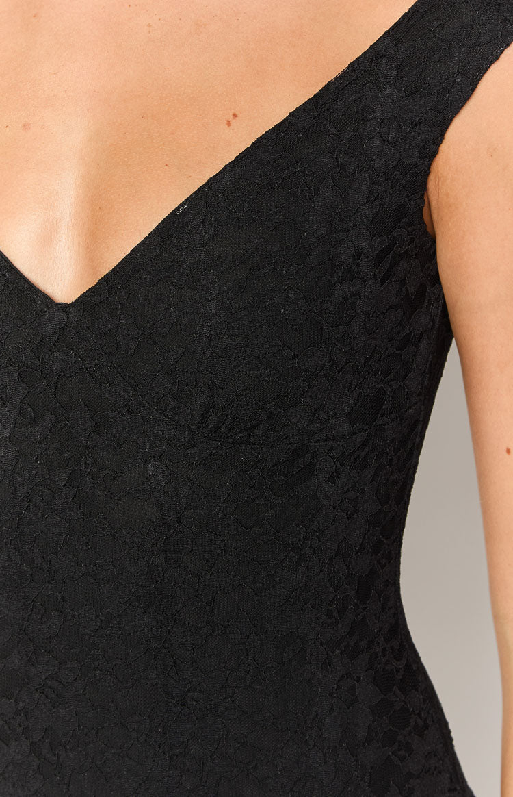 Close-up of the black lace V-neckline and the intricate floral pattern of the mini dress