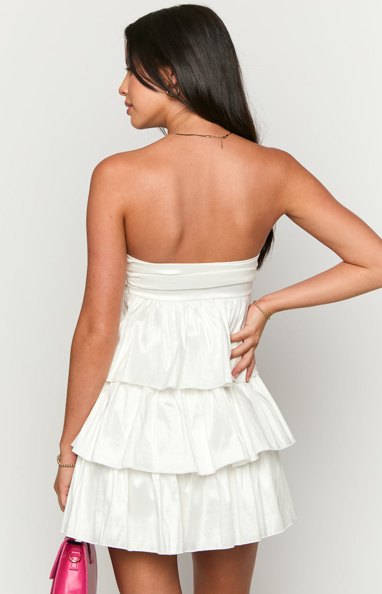 Back view of a white strapless mini dress with a three-tiered ruffled skirt in a slightly crinkled fabric