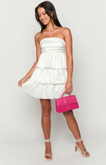 White strapless mini dress with a fitted bodice and a voluminous three-tiered ruffle skirt
