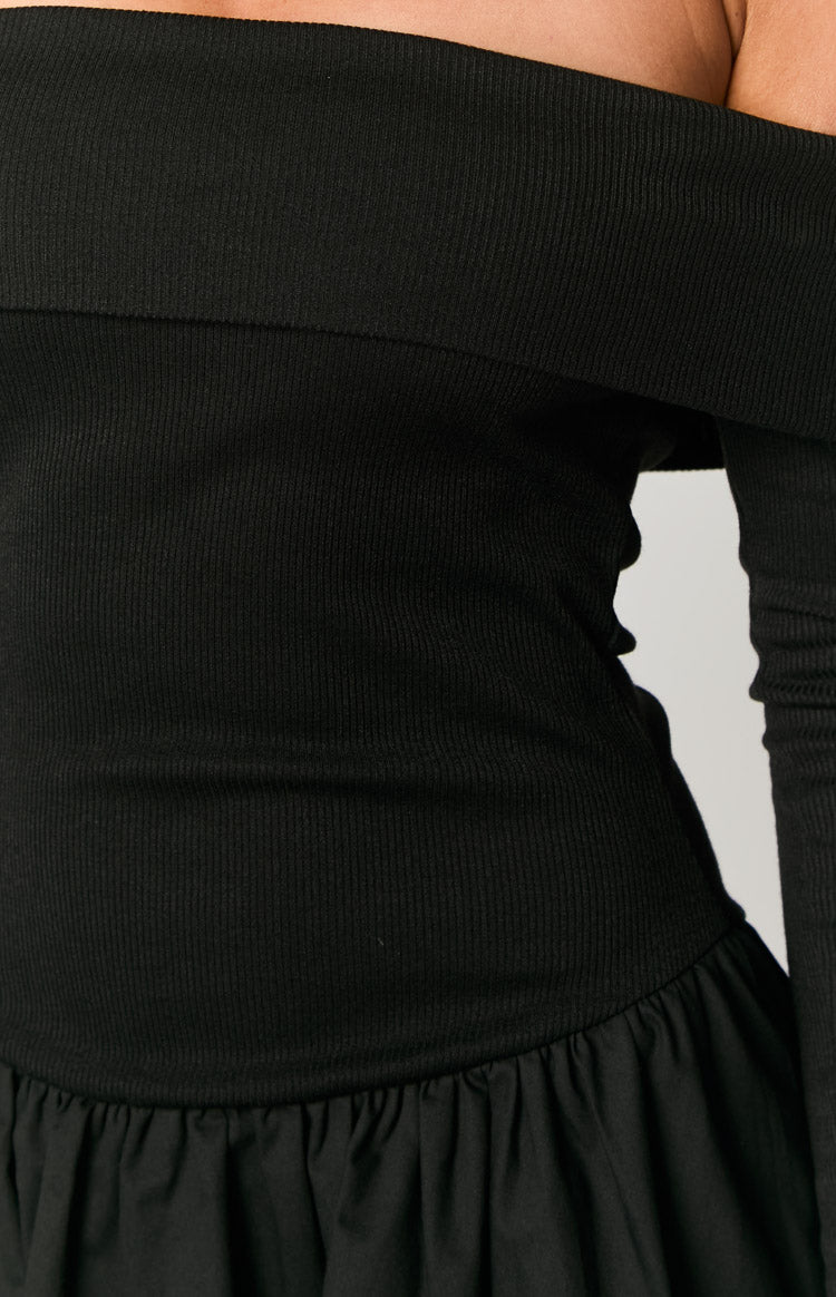 Close-up of the black ribbed off-shoulder neckline and fitted bodice above the gathered skirt of the mini dress