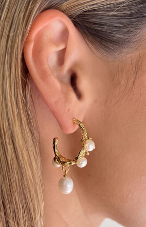 Close-up of the organic textured gold hoop earring featuring three embedded freshwater pearls and one dangling pearl