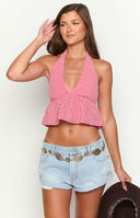 girl wearing red gingham halter crop top paired with light wash denim shorts