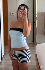 Front view of a light blue strapless top with a black contrast band and fitted cropped silhouette