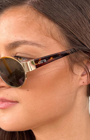 girl wearing gold frame sunnies with brown tortoiseshell details on the arms