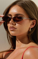 Close-up of the olive brown translucent cat eye sunglasses frame with OTRA branding on the temple