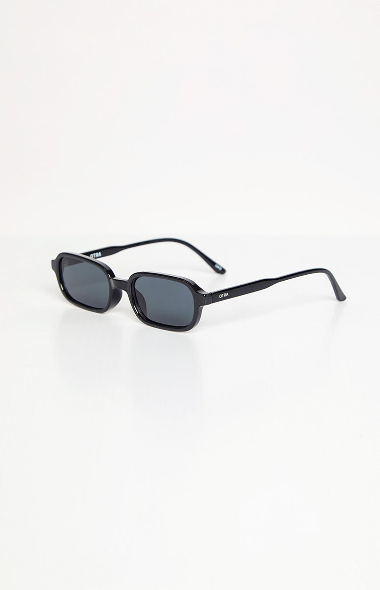 Angled view of black rectangle sunglasses with dark lenses and thick frames, showing the OTRA logo on the arm
