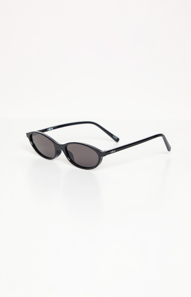 Side view of black cateye sunglasses with dark lenses and 'otra' logo on the temple arm