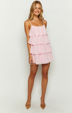Front view of a pink mini dress with a square neckline and four tiers of ruffles