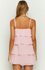 Rear view of a pink mini dress featuring four tiers of ruffles and thin spaghetti straps