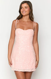 Front view of a light pink sequin mini dress with a sweetheart neckline and tie-up spaghetti straps