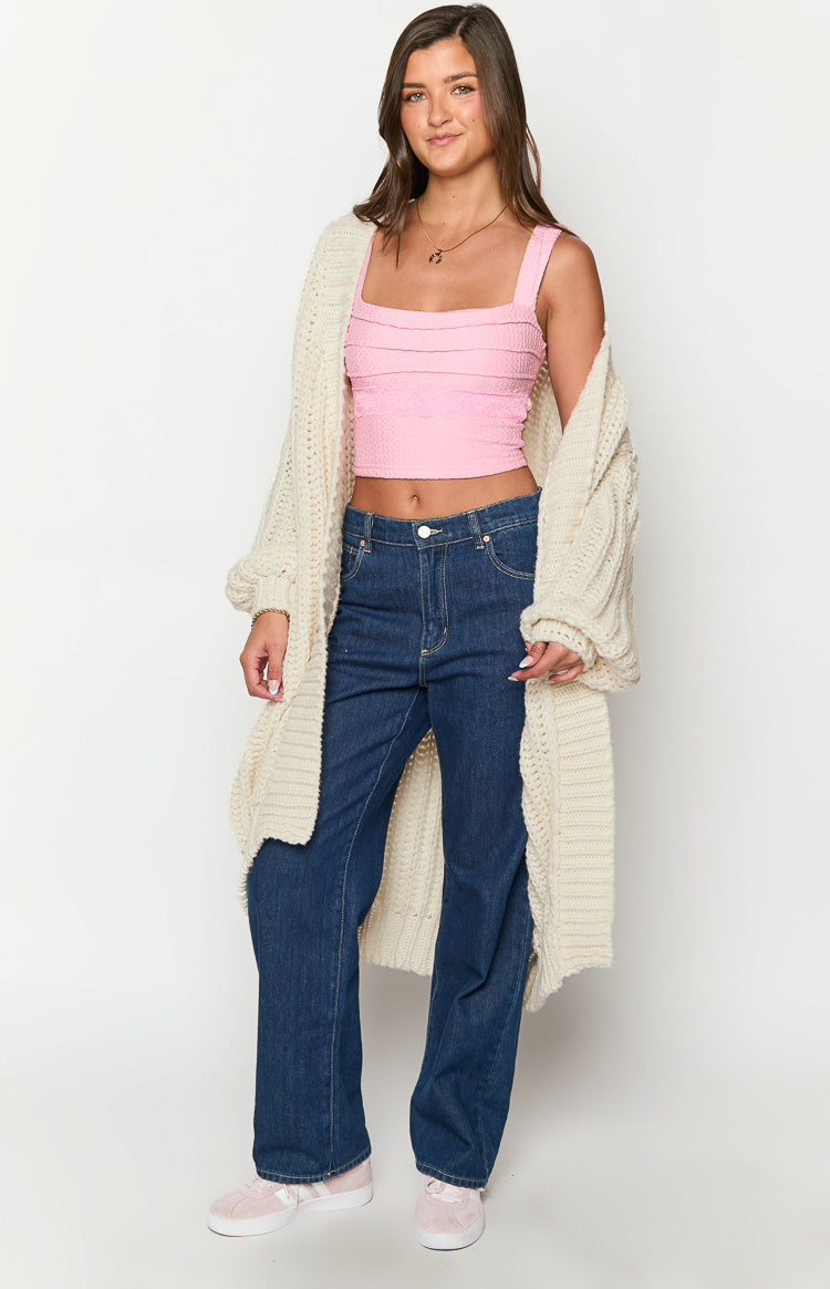 Front view of a cream chunky knit longline cardigan with wide sleeves, worn open