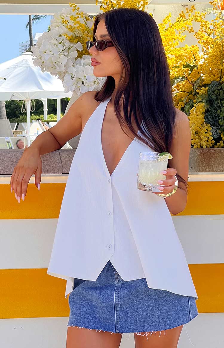 White linen blend halter top with deep V-neck, button-front, and asymmetrical flowy hem
