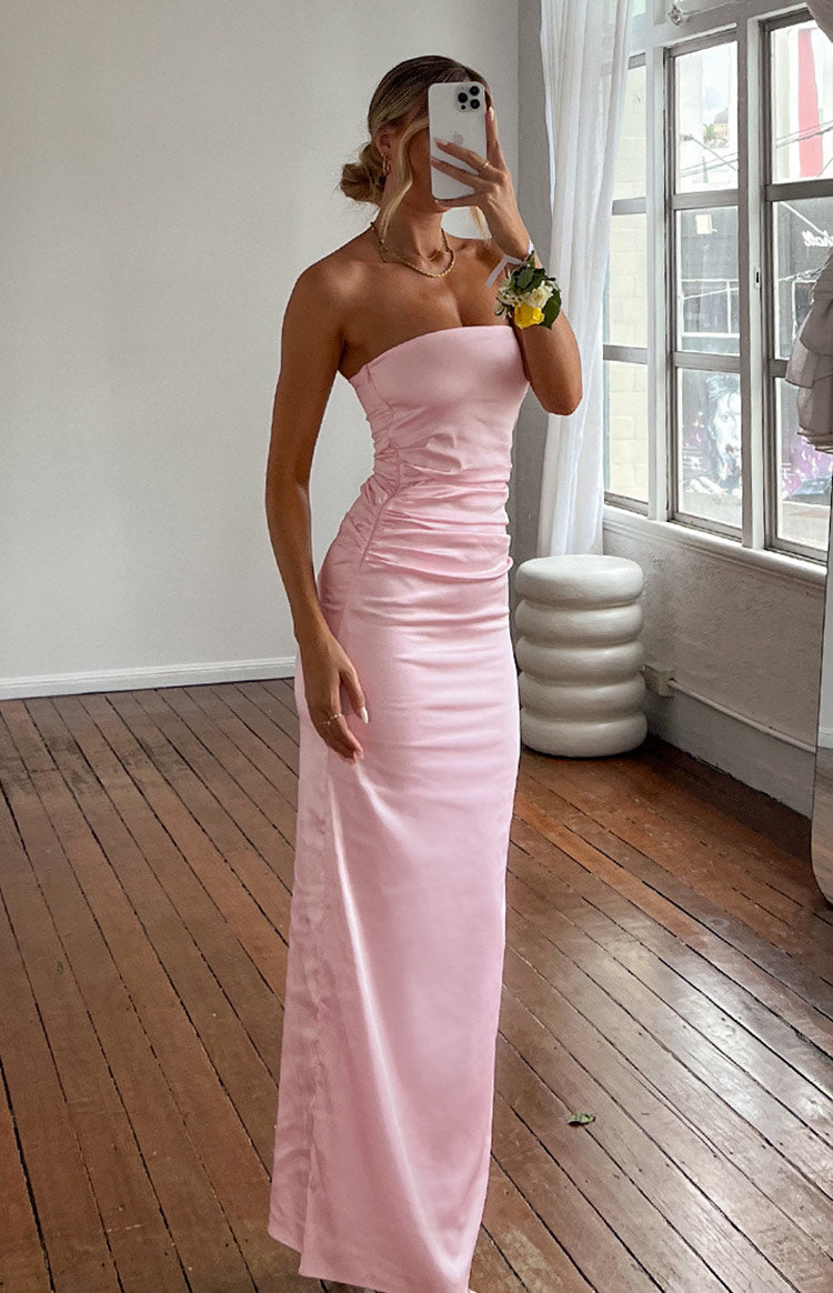 Full length view of a fitted pink satin strapless maxi dress with ruched side detail