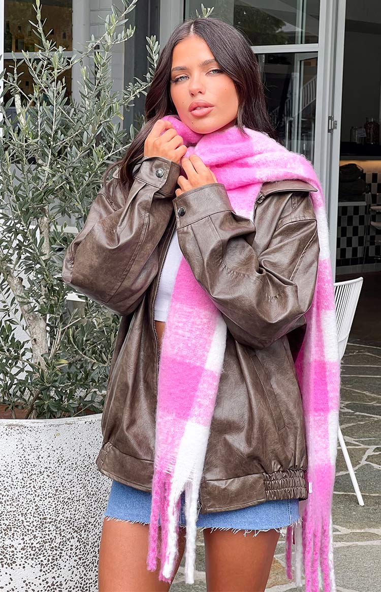 Fluffy pink and white check blanket scarf wrapped around the neck, showing the soft texture and fringe ends
