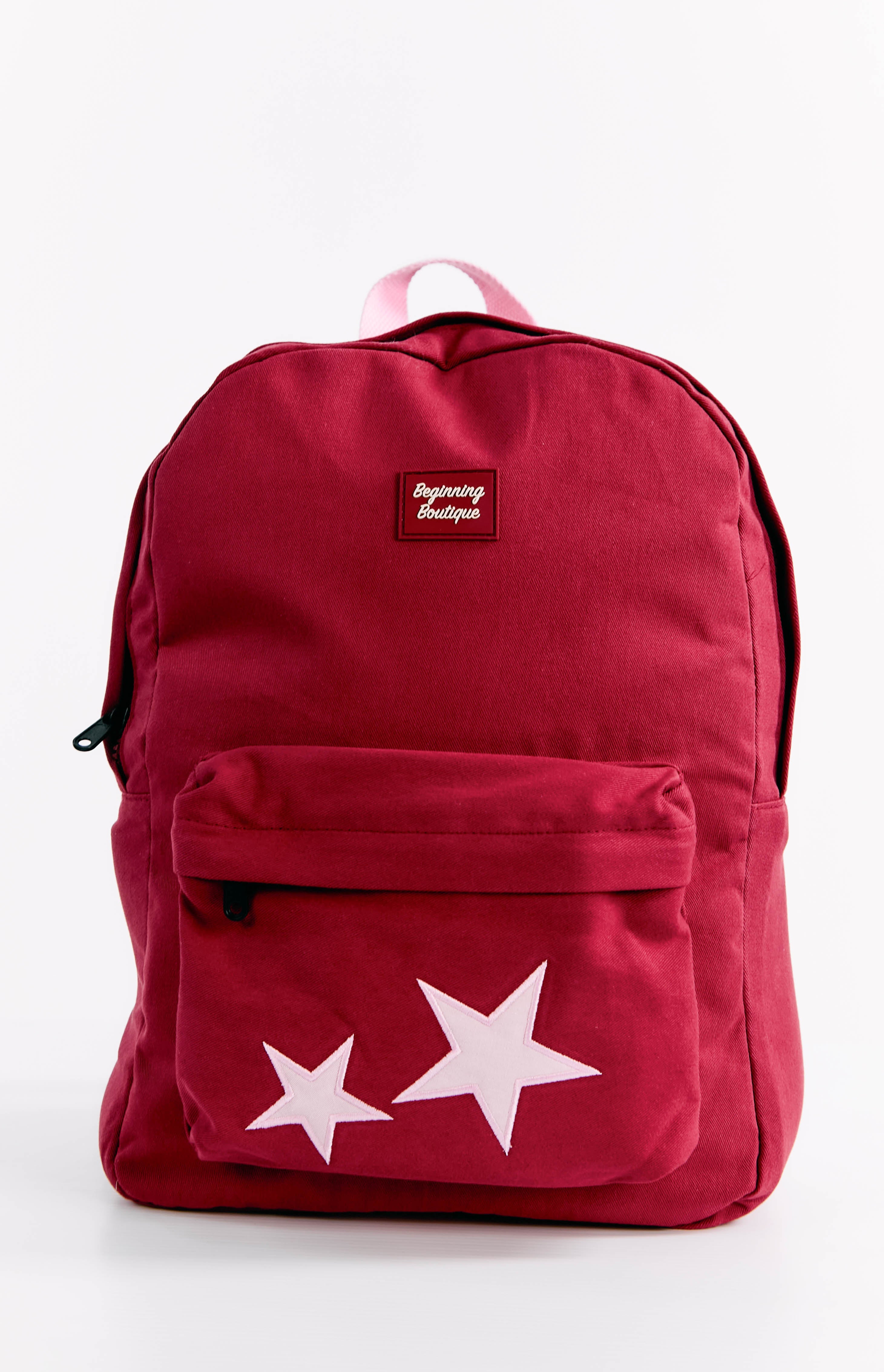 Front view of a burgundy backpack with two light pink stars on the front pocket and a pink top handle