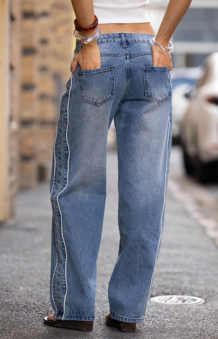 Rear view of mid wash wide leg jeans with white contrast seams and back pockets