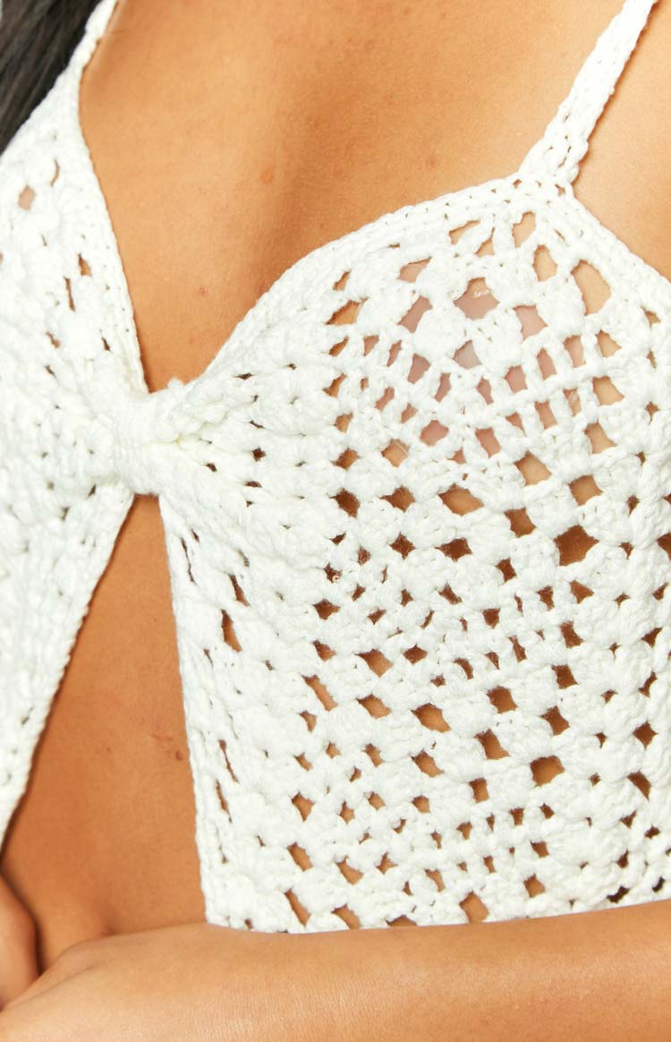 Close-up of the cream crochet knit top's open weave texture and twisted front knot detail