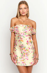 Primrose yellow off-the-shoulder mini dress with a ruffled neckline and vibrant pink and orange floral print