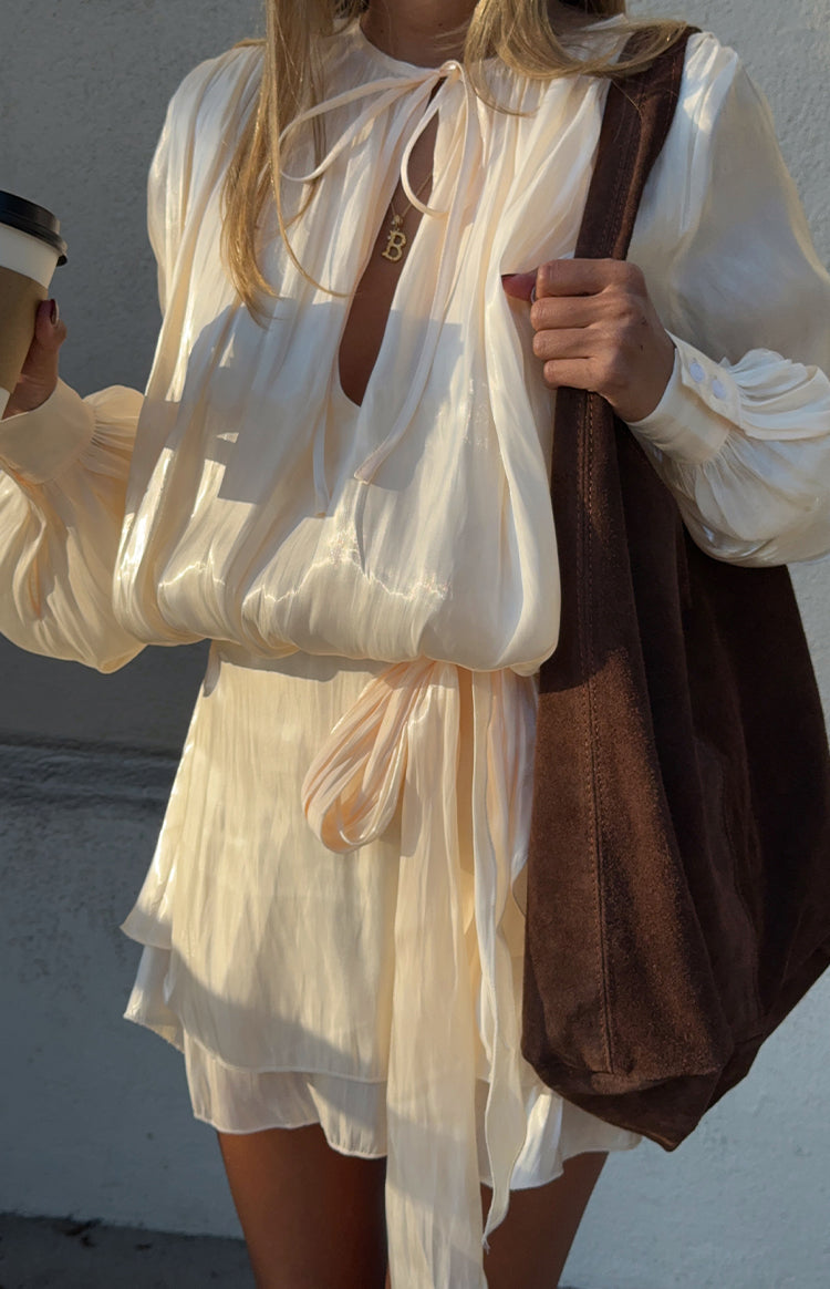 Close up of a flowy white satin mini dress with a tie waist detail perfect as a chic Wedding Guest outfit