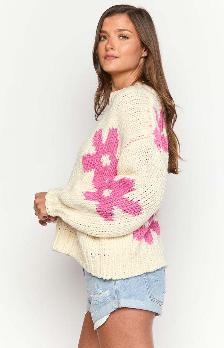 Side view of the cream chunky knit sweater with dropped shoulders and large pink flower patterns