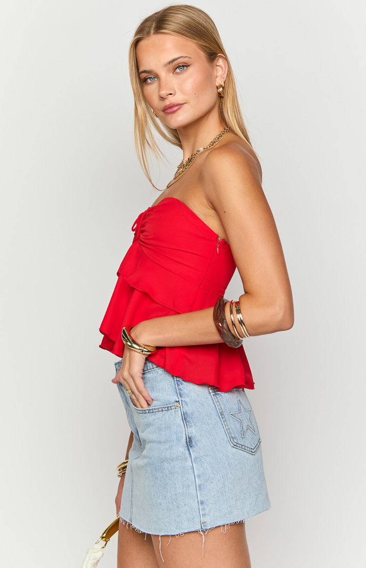 Side view of a red strapless top with a tiered ruffle peplum and a small invisible side zipper
