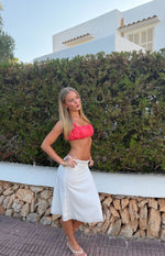 Side view of a flowy white satin midi skirt with delicate lace trim at the high waist