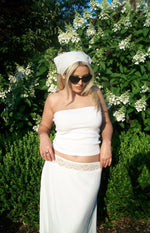 White midi skirt with delicate white lace trim visible at the low-rise waistline