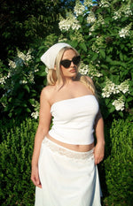 Close-up of the white midi skirt showing the delicate lace trim detail at the waist