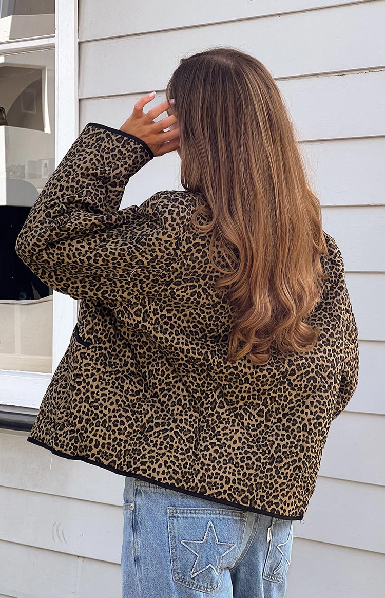 Rear view of a brown and black leopard print quilted jacket showing the textured quilting and black trim