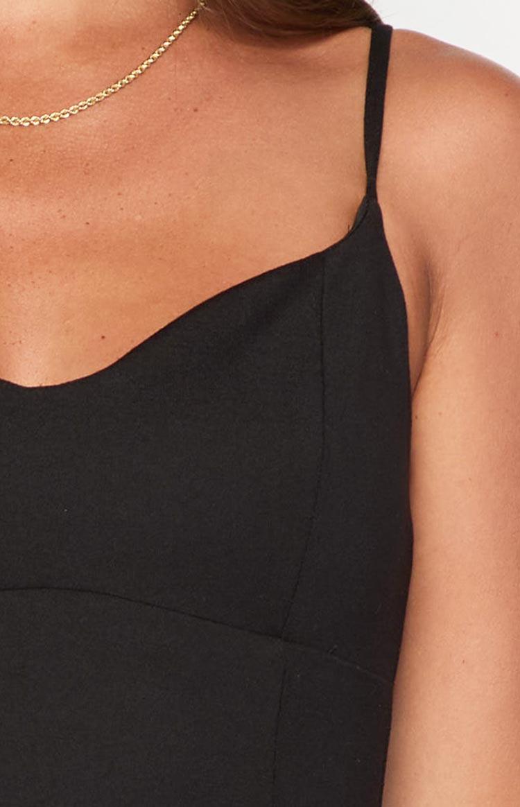 Close-up of the black mini dress bodice with sweetheart neckline, thin spaghetti strap, and vertical seaming